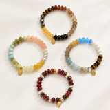 4 colorful beaded bracelets are layed evenly on the white background