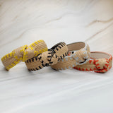 Raffia headband with vibrant color-stitched detail in a knotted design, offering a fun and summery look.
