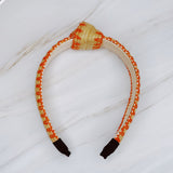 Raffia headband with vibrant color-stitched detail in a knotted design, offering a fun and summery look.