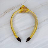 Raffia headband with vibrant color-stitched detail in a knotted design, offering a fun and summery look.