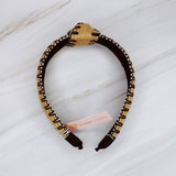 Raffia headband with vibrant color-stitched detail in a knotted design, offering a fun and summery look.