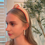 Raffia headband with vibrant color-stitched detail in a knotted design, offering a fun and summery look.