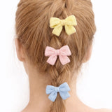 A cozy knit bow hair clip set featuring pastel-colored bows in soft shades of blue, pink, cream. Each bow is made from a textured knitted fabric, adding a charming and delicate touch to any hairstyle. Perfect for everyday wear or as a sweet accessory accent