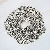 Stylish hair scrunchie featuring a bold cheetah print with delicate crochet trim, blending wild flair with a touch of handcrafted charm.