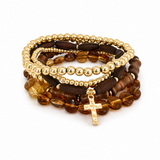 Stack of beaded bracelets with gold accents on a white background