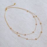 Elegant layered necklace featuring delicate gold chains accented with crystal bezel stations, perfect for a subtle sparkle and refined style.