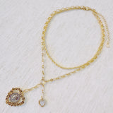 Layered gold-tone necklace featuring dual chain links and a vintage-inspired heart pendant centerpiece—offering a romantic, bold accent perfect for elevating any look.