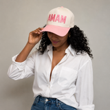 A model wearing MAMA embroidered in bold font in pink thread, pink tone brim baseball
