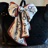 Scarf featuring an elegant equestrian-inspired chain link border design, ideal for accessorizing the neck, hair, or handbag handles.