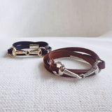 Equestrian-inspired double wrap bracelets featuring black and brown leather bands with horse bit accents in gold and silver tones.