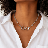 Silver chain necklace with a unique clasp worn by a person in a white shirt.