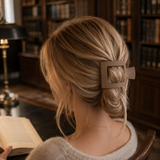 Person with a decorative hair clip sitting in a library.
