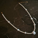 Gold-tone chain necklace featuring a mix of small polished pearls and irregular freshwater-style pearls, finished with an adjustable clasp closure.