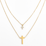 Gold-toned layered necklace featuring two sleek cross pendants, one on each tier of delicate chain links for a modern, faith-inspired design.