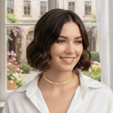 Gold-tone modern herringbone necklace featuring a sleek, flat chain design with subtle reflective shine and a secure clasp closure