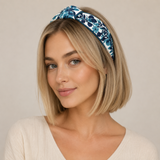 Woman wearing a blue floral headband against a beige background