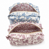 2 floral toile print cosmetic cases in blue and pink with ruffle details on top around gold zipper, zipper opened and inside has floral lining, white background