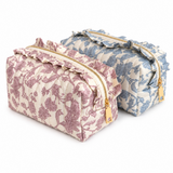 2 floral toile print cosmetic cases with ruffle details on top with gold zippers lined up. white background