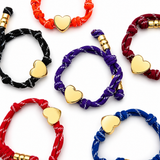 multiple different colors rope bracelets with gold heart charm on the white background