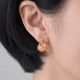Artistic drop earrings featuring prism-cut gemstones framed by lustrous gold-tone metal. The angular yet fluid silhouette captures light beautifully, making each pair an elegant statement piece.