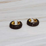 A pair of gold-tone hoop earrings adorned with shimmering rhinestones