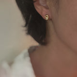 Gold-tone dome stud earrings with a smooth, pebble-like shape and a polished finish for a modern, minimalist look.