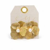 Gold floral earrings with pearl centers on a beige card with gold text.