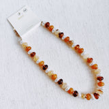 Beaded necklace featuring a blend of golden, amber, and brown-toned beads with subtle shimmer and natural variation, creating an earthy yet refined look.