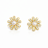 Gold-tone floral stud earrings featuring a luminous pearl center surrounded by petal-shaped sections adorned with sparkling crystals. The earrings create a radiant, feminine look that blends timeless charm with elegant shine.