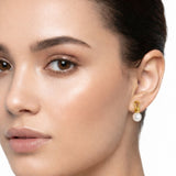 Elegant pearl drop earrings featuring smooth white pearls suspended from sculpted gold loops. The design blends modern artistry with timeless sophistication, creating a refined accessory for everyday or formal wear.