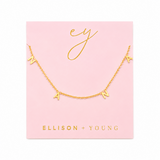 Gold necklace with 'A' pendant on Ellison + Young branded card