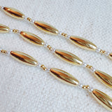 Gold-toned necklace featuring sleek tube beads – minimalist and modern layered style