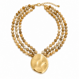 Multistrand beaded necklace with a gold pendant on a white background