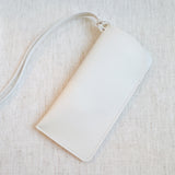 Glass case bag charm with an open-top design and strap attachment, perfect for hanging on your bag to hold glasses or other small essentials in style.