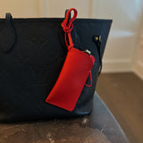 Glass case bag charm with an open-top design and strap attachment, perfect for hanging on your bag to hold glasses or other small essentials in style.