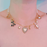 Gold-tone charm necklace featuring a mix of heart, bow, and angel motifs alongside vintage-style accents—blending sweet, romantic elements into a charming statement piece.
