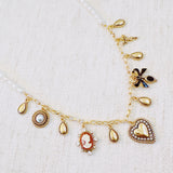 Gold-tone charm necklace featuring a mix of heart, bow, and angel motifs alongside vintage-style accents—blending sweet, romantic elements into a charming statement piece.