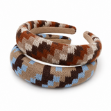 Two knitted headbands stacked on a white background. The top headband has a geometric pattern of brown, beige, and cream, while the bottom headband has a matching pattern with light blue accents.