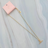 A gold chain necklace featuring a sparkling pavé T-bar pendant. The design combines a classic toggle motif with shimmering details for a sophisticated and modern finish.