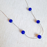 Elegant necklace featuring flowing indigo-toned beads—designed to capture graceful movement and add a touch of sophistication to any look.