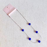 Elegant necklace featuring flowing indigo-toned beads—designed to capture graceful movement and add a touch of sophistication to any look.