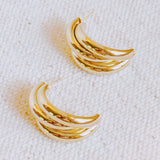 Statement earrings featuring bold interlocking loops in a polished gold-tone finish—offering a modern, sculptural look with standout appeal.