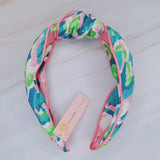Knotted headband in tropical-inspired colors, evoking an island vacation feel.