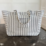 Oversized beach bag made from plush terry cloth material, designed with sturdy handles and a spacious interior—perfect for carrying towels, swimwear, and summer essentials in cozy, absorbent style.