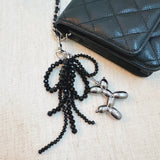 Pink & black beaded bow with a gold balloon dog charm – playful and chic design