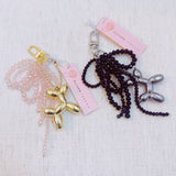 Pink & black beaded bow with a gold balloon dog charm – playful and chic design
