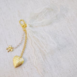 White lace ribbon bag charm with dangling gold heart charm – romantic vibe