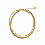 thinner and wider Herringbone chains layered together as an anklet in yellow gold tone on the white background