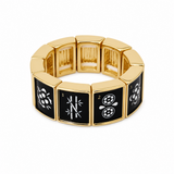 A gold-plated segmented bracelet with black enamel panels featuring white floral and geometric designs, shown on a plain white background.