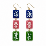 A pair of drop earrings with gold-tone fishhook wires and three rectangular dangling charms. Each earring has a blue top charm with a white bird and floral motif, a pink middle charm with white wheel motifs, and a green bottom charm with white bamboo and branch motifs.